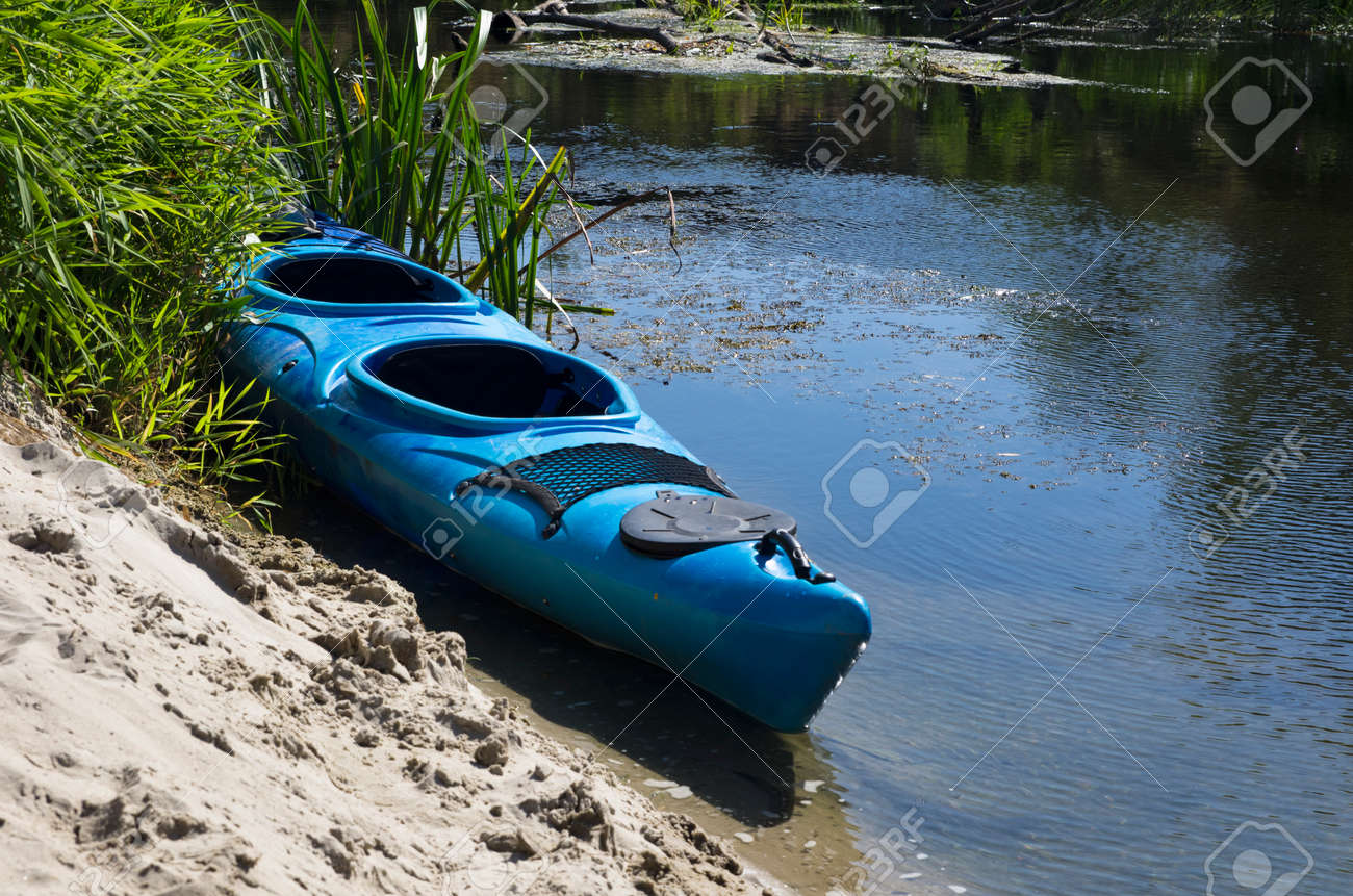 Kayak on the sandy shore of a small river - 146541757 Kayak on the sandy shore of a small river - 146541757