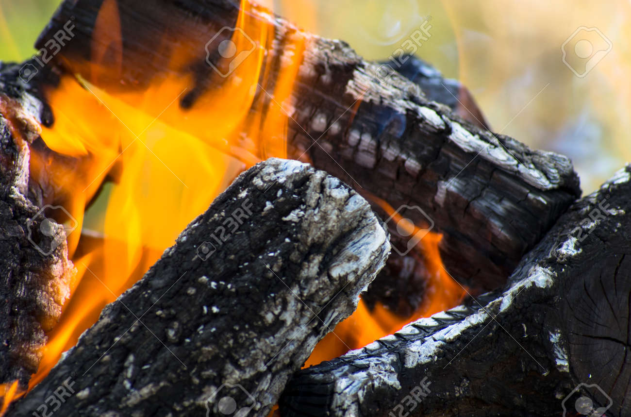 Dark logs of firewood burn in flames - 159935453 Dark logs of firewood burn in flames - 159935453