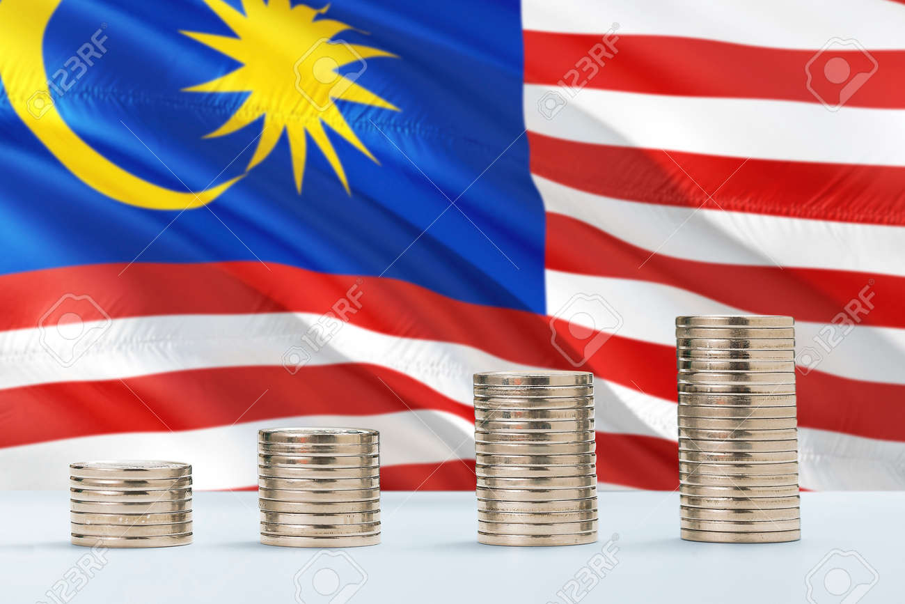 금융과 비즈니스 개념을 위해 동전이 줄지어 늘어선 배경에 말레이시아 국기가 흔들리고 있습니다. 돈을 절약. 로열티 무료 사진, 그림,  이미지 그리고 스톡포토그래피. Image 122682161