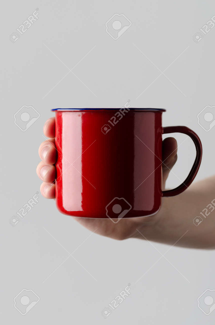 赤いエナメル マグカップ モックアップ 男性両手で灰色の背景にエナメル マグカップ の写真素材 画像素材 Image