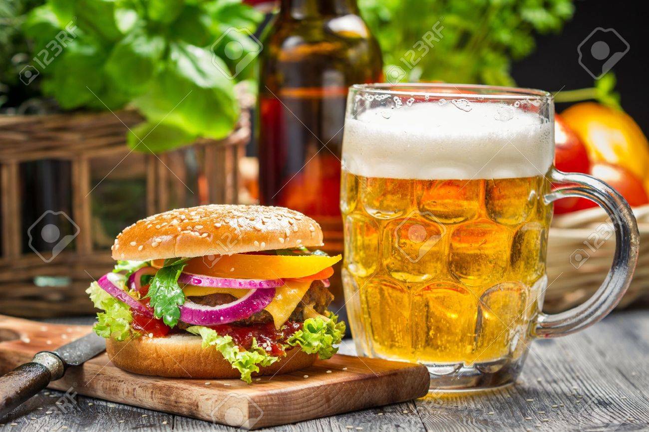 Closeup Of Fresh Burger And A Cold Beer Stock Photo, Picture and Royalty  Free Image. Image 18701030., image size:1300x866