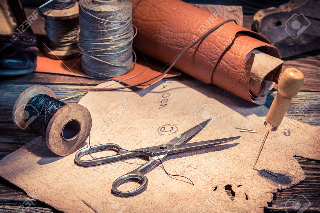 Closeup of vintage cobbler workplace with shoes, laces and tools - 128701723 Closeup of vintage cobbler workplace with shoes, laces and tools - 128701723