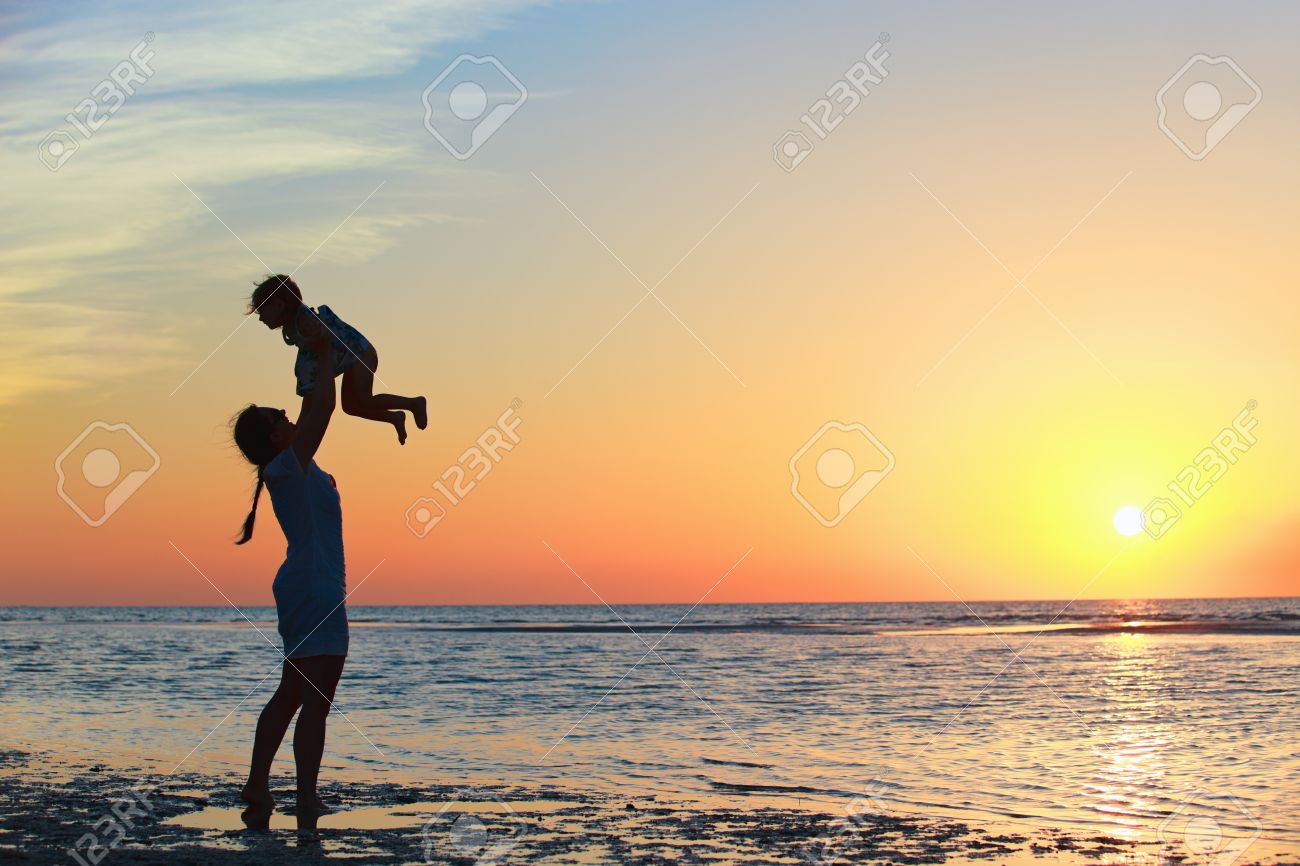 Mother and little daughter silhouettes on beach at sunset - 9862599 Mother and little daughter silhouettes on beach at sunset - 9862599