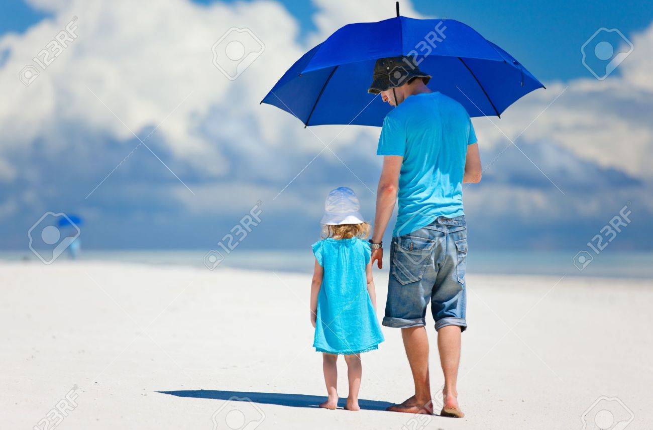 Father and daughter at beach with umbrella to hide from sun - 15892614 Father and daughter at beach with umbrella to hide from sun - 15892614