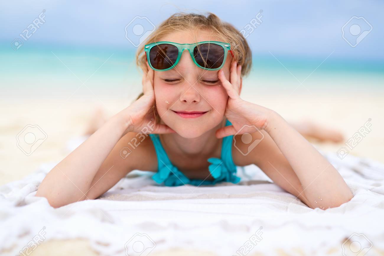 Adorable Petite Fille Couchée Sur Une Serviette De Plage Pendant Les ... Adorable Petite Fille Couchée Sur Une Serviette De Plage Pendant Les ...