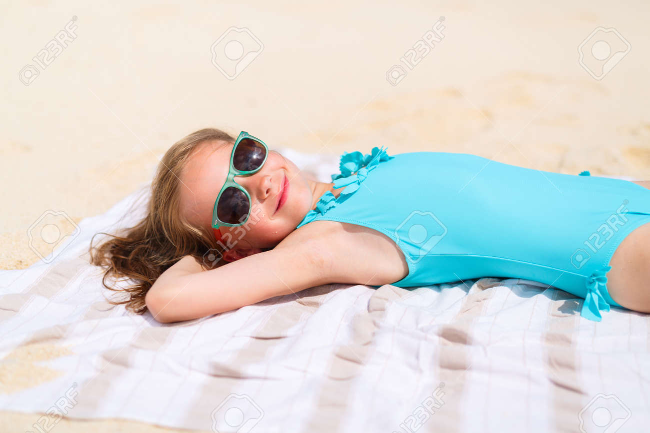 Adorable Petite Fille Couchée Sur Une Serviette De Plage Pendant Les ... Adorable Petite Fille Couchée Sur Une Serviette De Plage Pendant Les ...