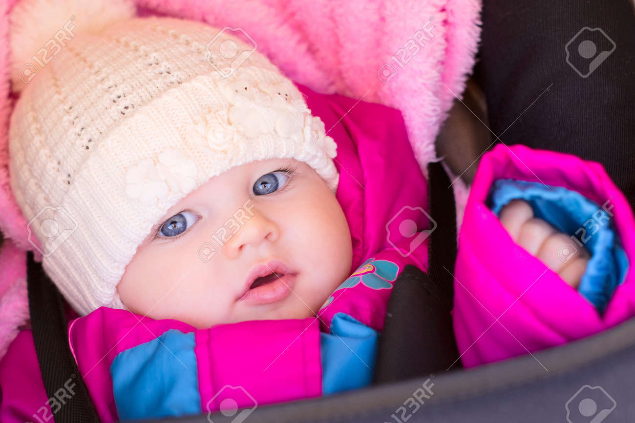 portrait of little baby girl in purple rose jaket and hat stock