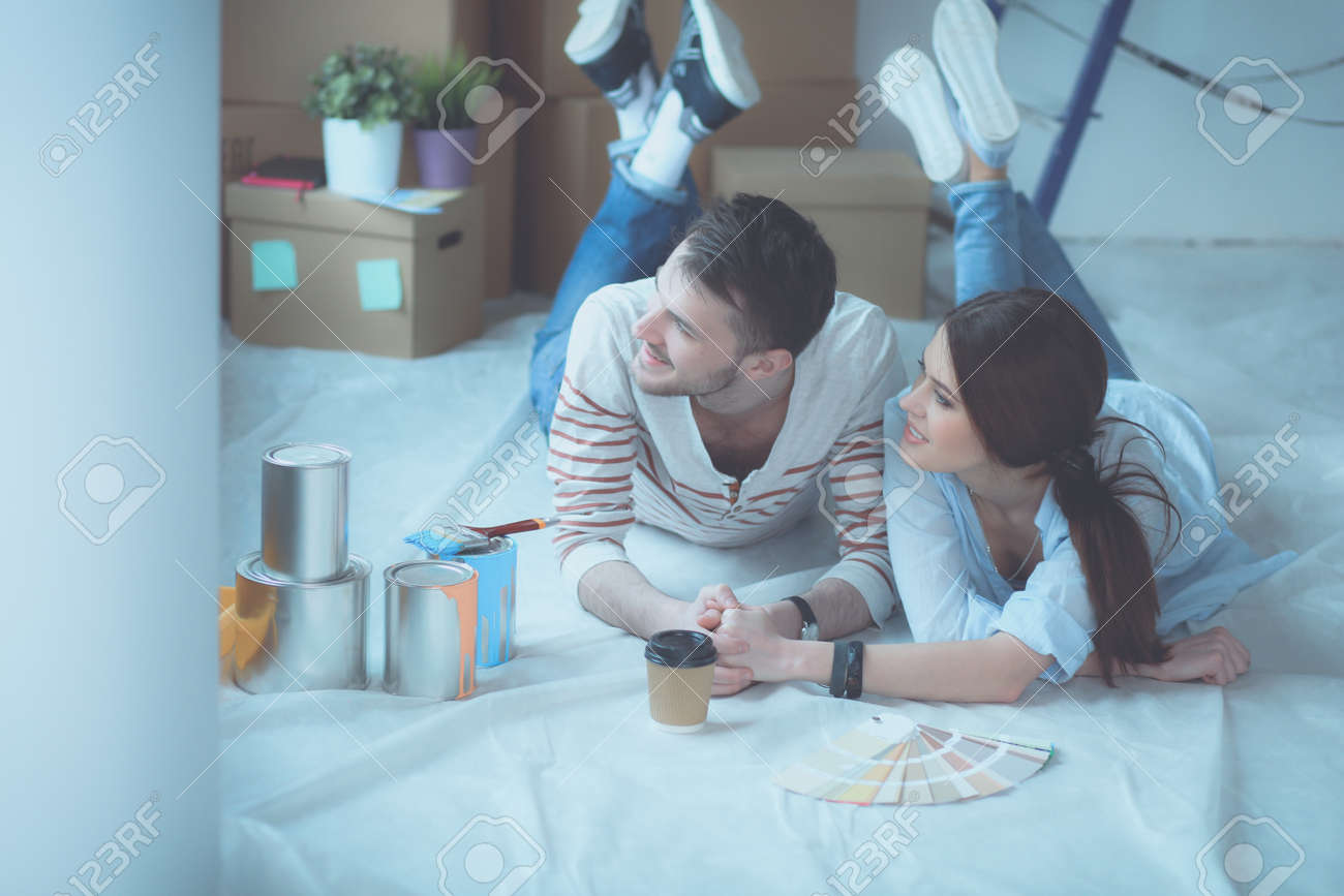 Couple Choosing Paint Colour From Swatch For New Home Lying On