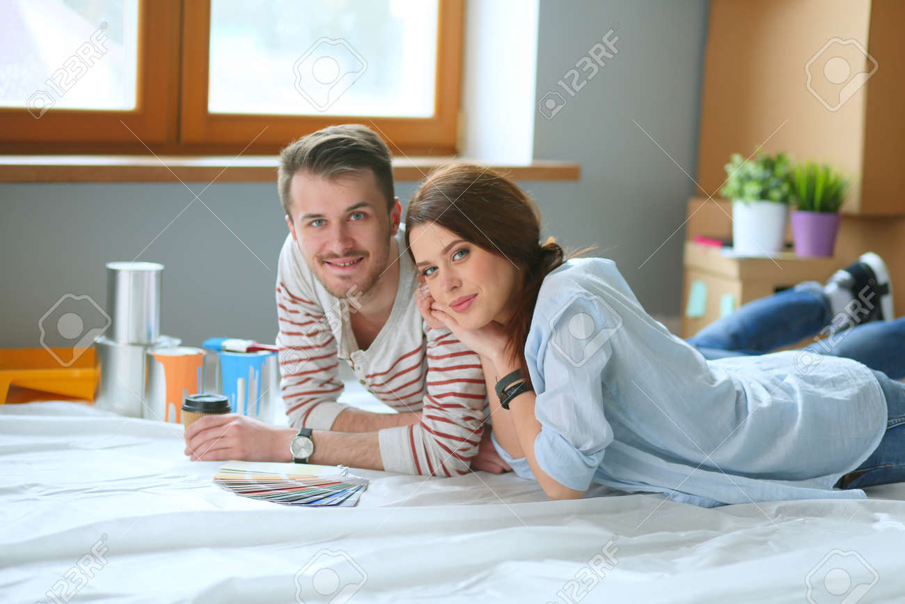 Couple Choosing Paint Colour From Swatch For New Home Lying On