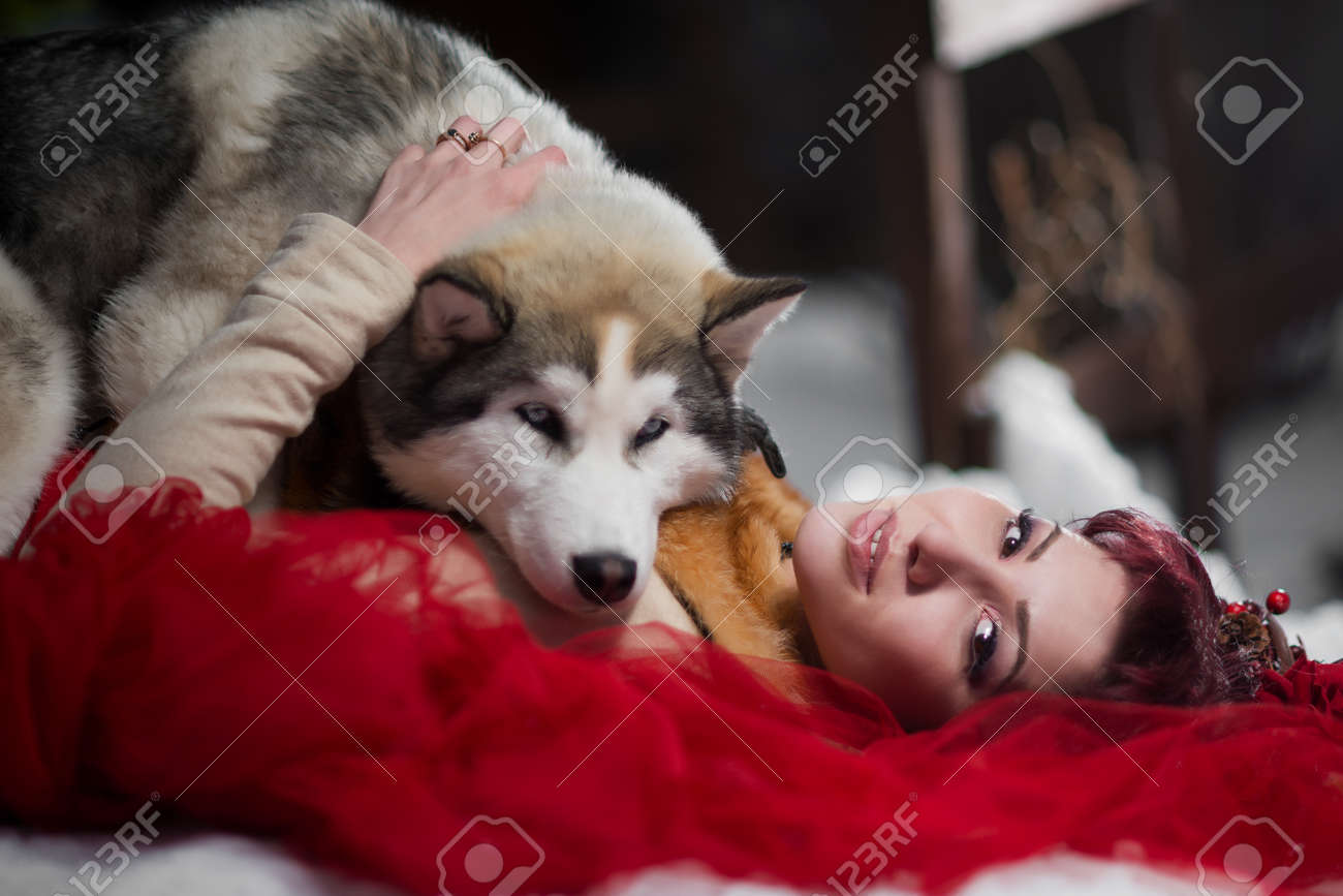 Belle Femme En Robe Rouge Avec Des Chiens Husky Ressemble à Un Loup