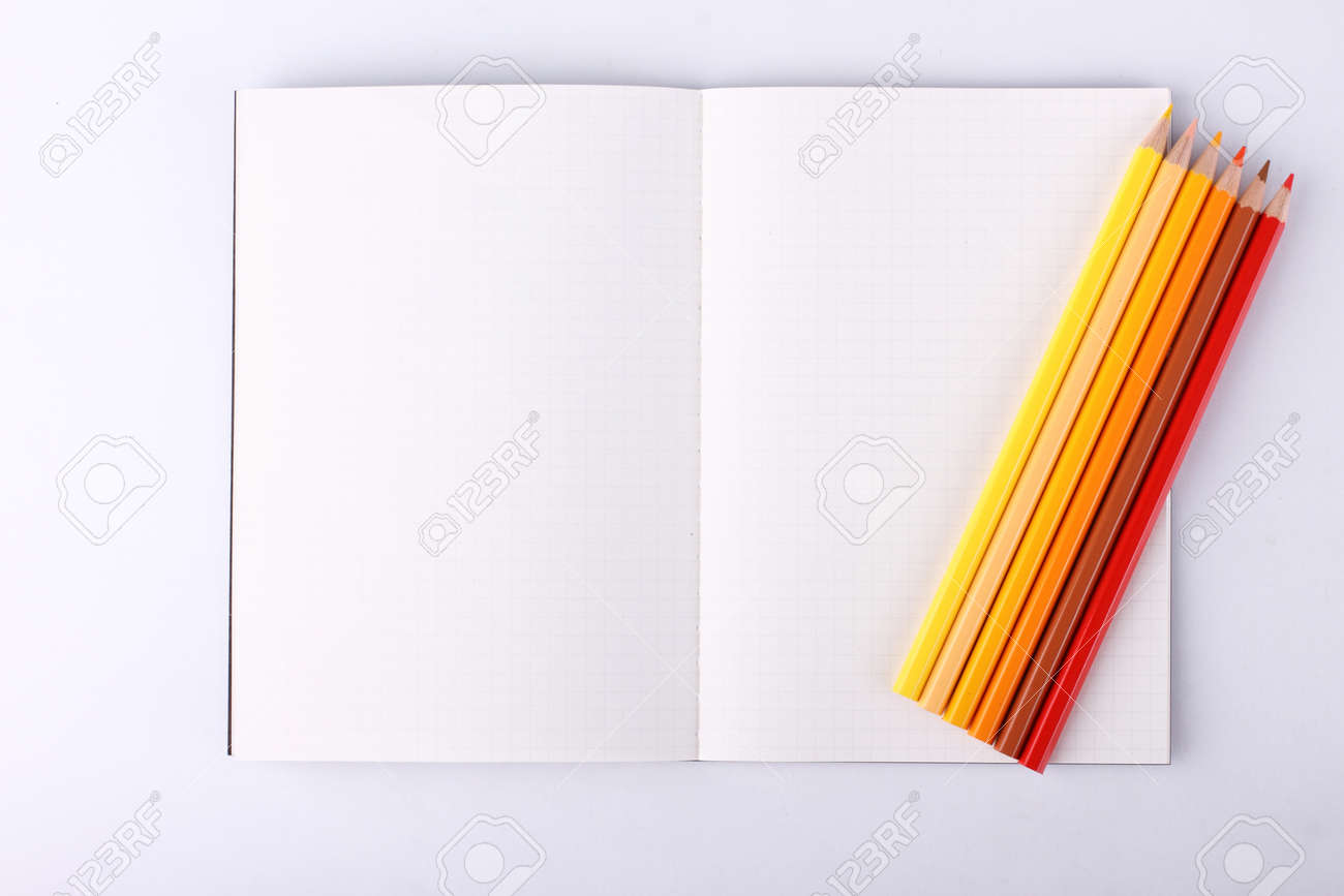 colour pencils with blank notebook isolated on white background