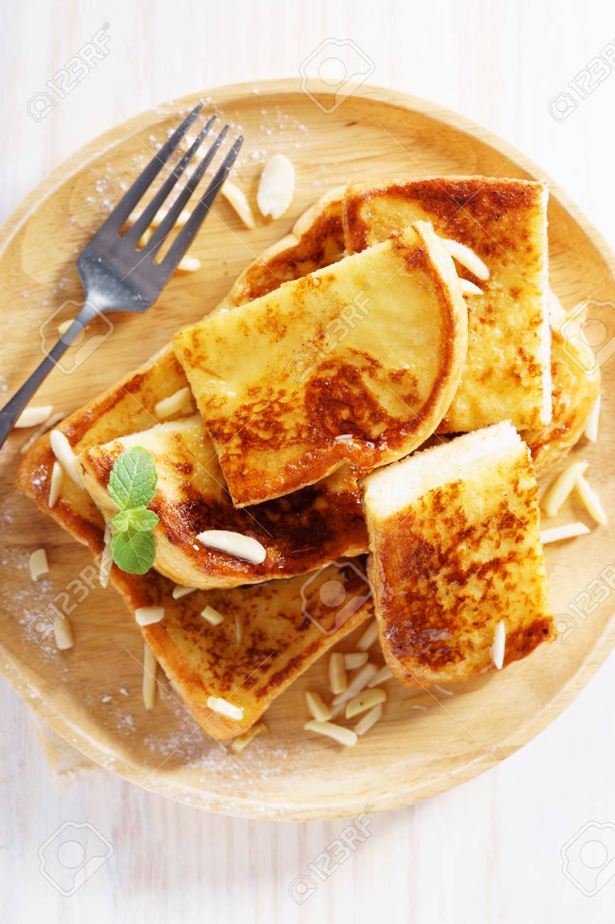 French Toast With Honey Syrup And Almond Flakes On Wooden Plate Stock Photo Picture And Royalty Free Image Image 97289914