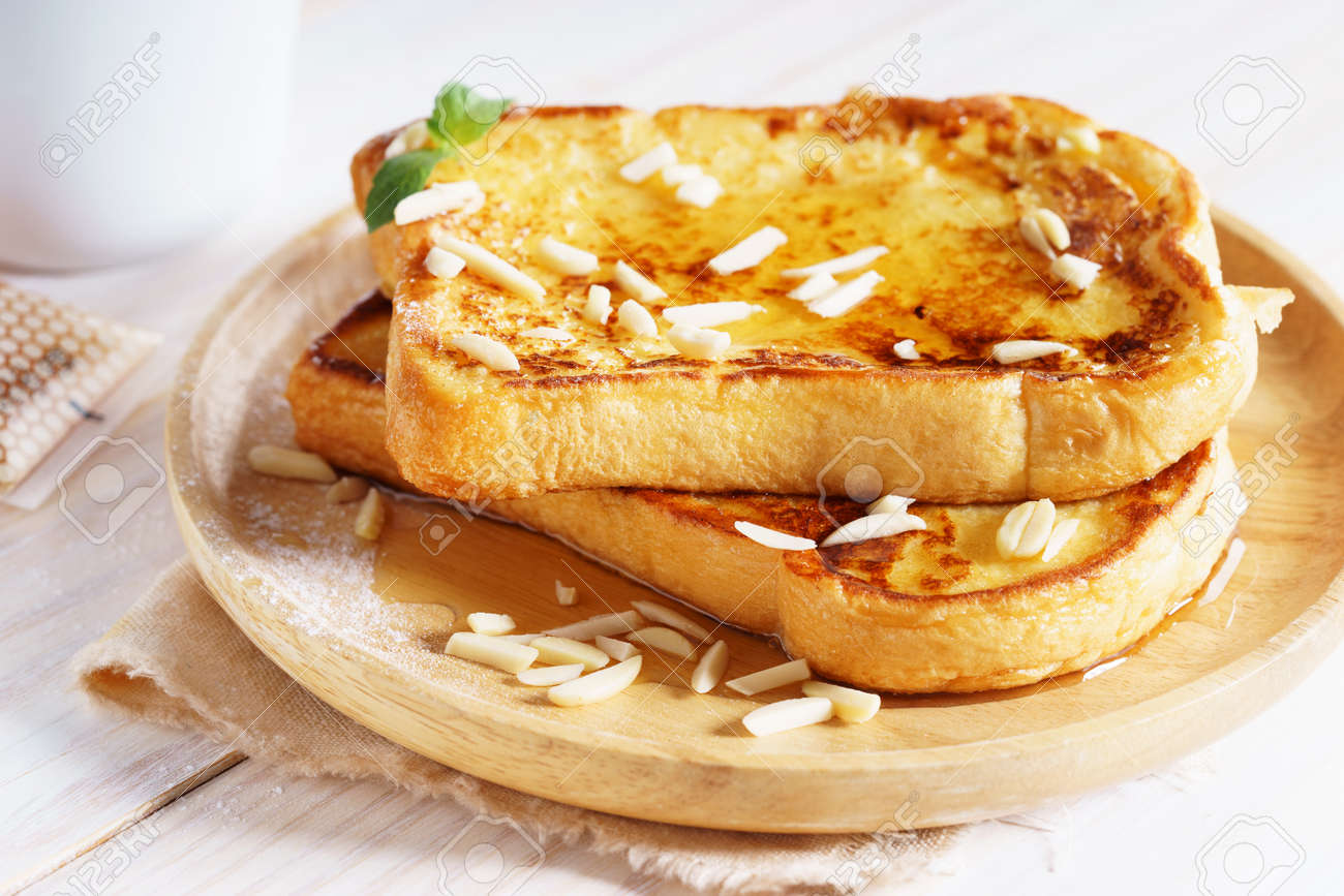 French Toast With Honey Syrup And Almond Flakes On Wooden Plate Stock Photo Picture And Royalty Free Image Image 97239520
