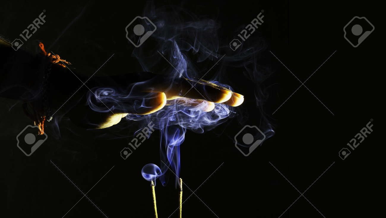 hand over smoke from an incense stick for divine religious blessings