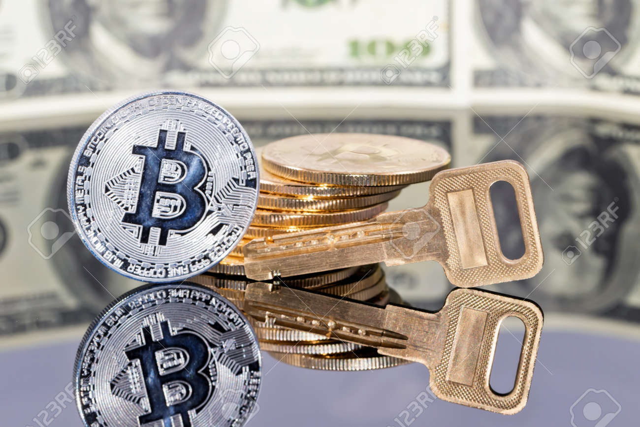 비트 코인 금화의 스택과 통화 금고의 열쇠는 반사 표면에 백 달러 지폐의 배경에 거짓말 로열티 무료 사진, 그림, 이미지 그리고  스톡포토그래피. Image 98040192