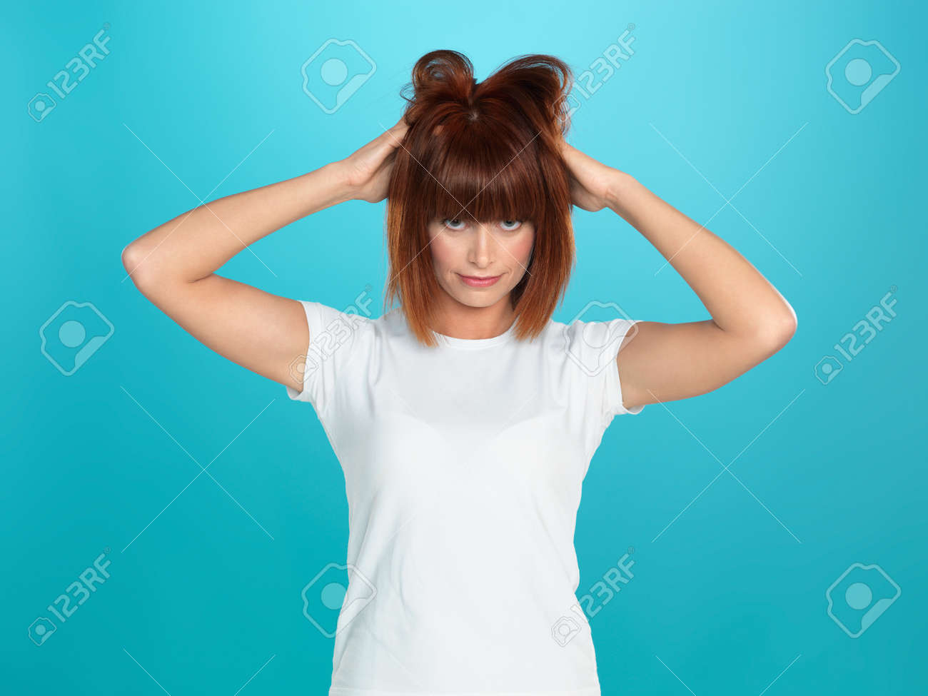 美しい 若い女性の青の背景に 髪をいじるの写真素材 画像素材 Image