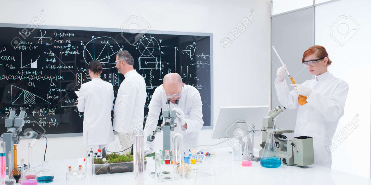 general view of four people in a chemistry lab conducting chemistry lab experiments