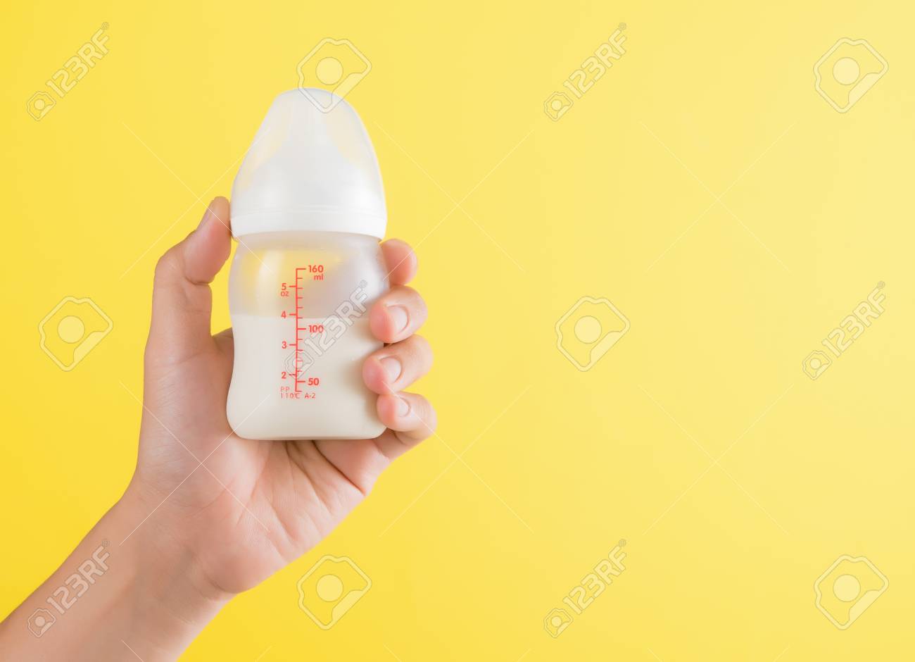 Download Hand Holding A Baby Bottle Of Milk On Yellow Background Stock Photo Picture And Royalty Free Image Image 92685785 Yellowimages Mockups
