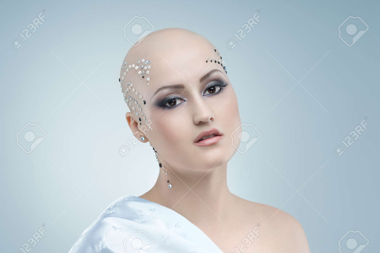 studio portrait of a beauty bald girl on a sky blue background