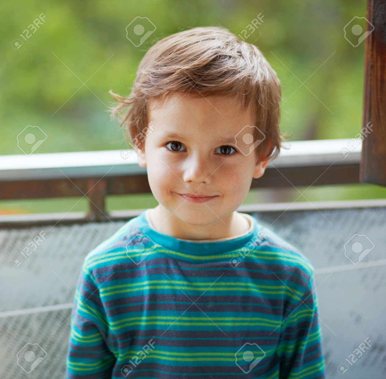 portrait of a small boy standing and smiling to you stock photo