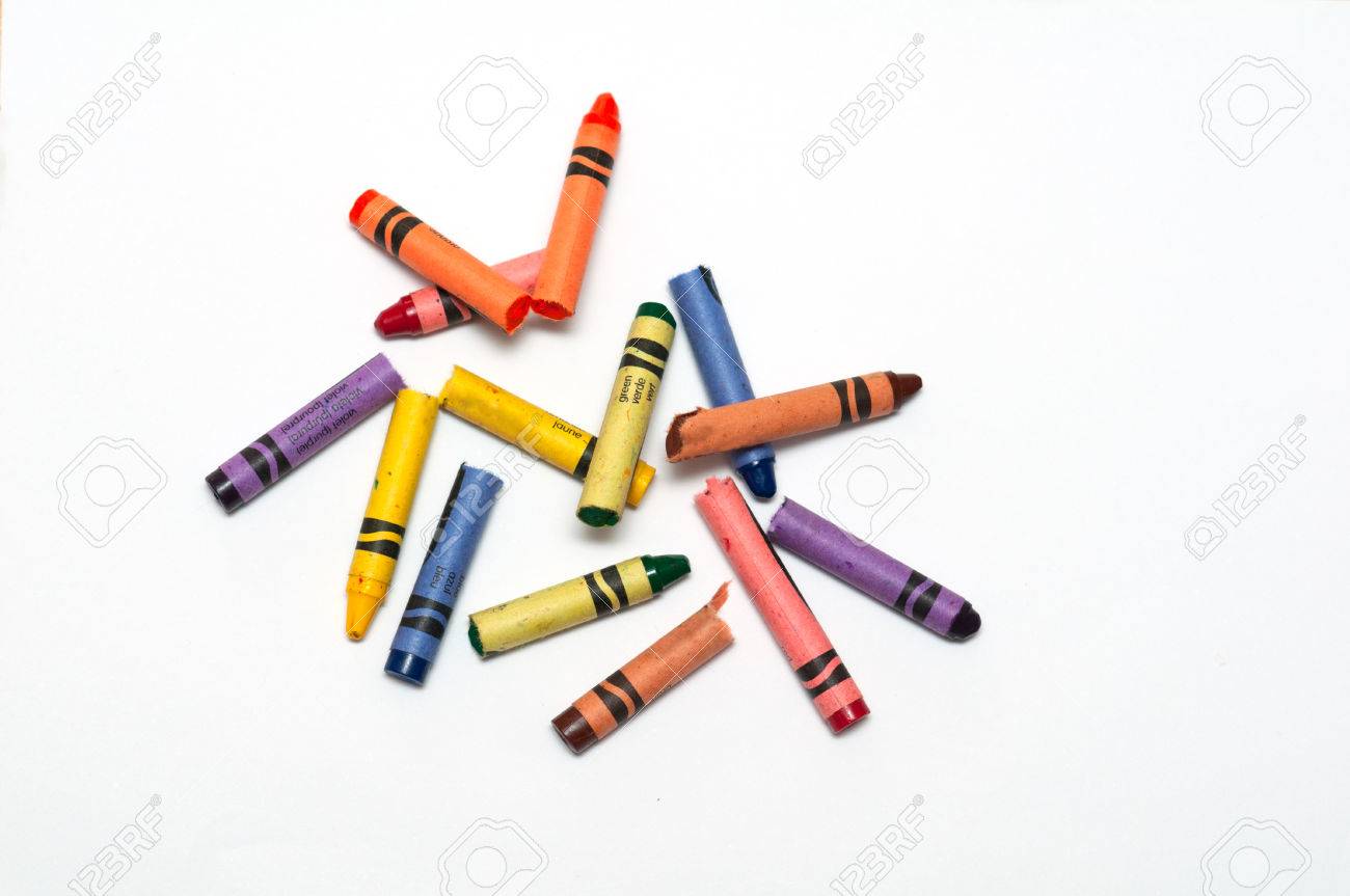 Broken Crayons Laying On A White Sheet 