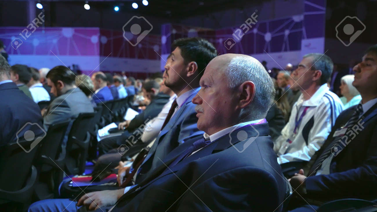 Russia, Novosibirsk, 21 sep, 2019: Crowd people listen speaker. Audience business meet forum. Auditorium viewer listen speaker. political summit business man. Group people listening speech crowd. - 156208846 Russia, Novosibirsk, 21 sep, 2019: Crowd people listen speaker. Audience business meet forum. Auditorium viewer listen speaker. political summit business man. Group people listening speech crowd. - 156208846