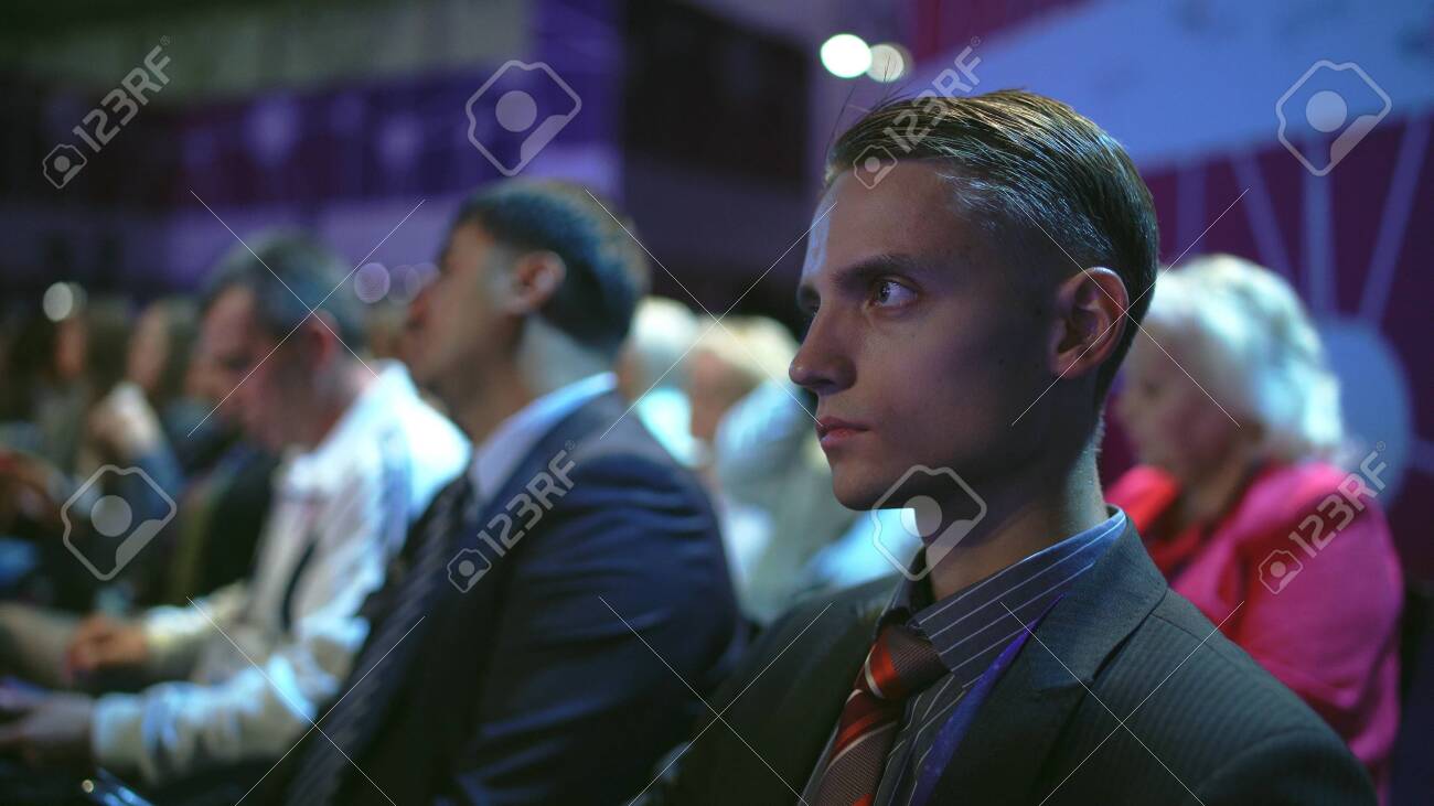 Russia, Novosibirsk, 21 sep, 2019: Crowd people listen speaker. Audience business meet forum. Auditorium viewer listen speaker. political summit business man. Group people listening speech crowd. - 156208845 Russia, Novosibirsk, 21 sep, 2019: Crowd people listen speaker. Audience business meet forum. Auditorium viewer listen speaker. political summit business man. Group people listening speech crowd. - 156208845