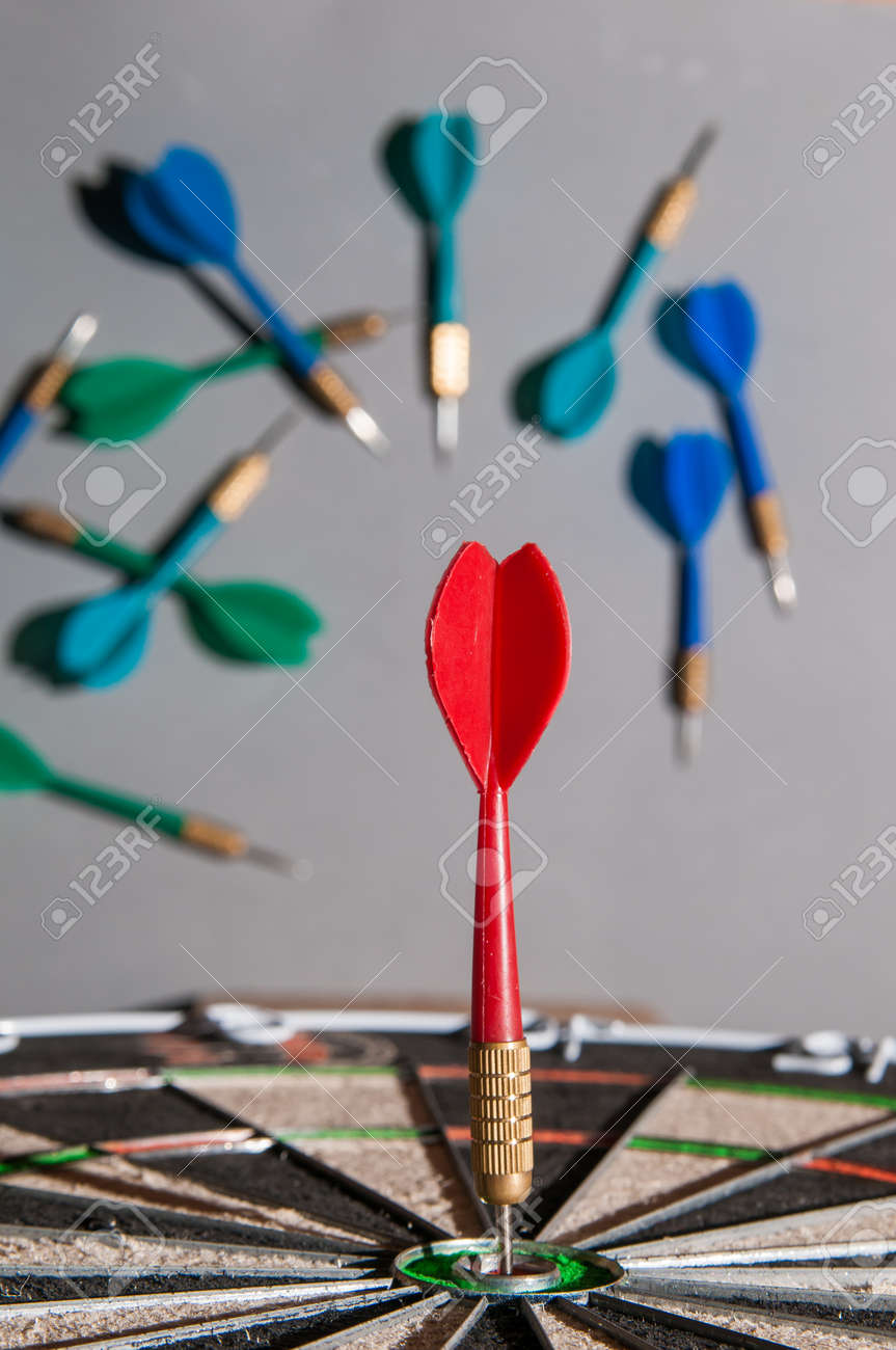 Red Dart On The Bullseye Of A Dartboard And Some Failed Shots