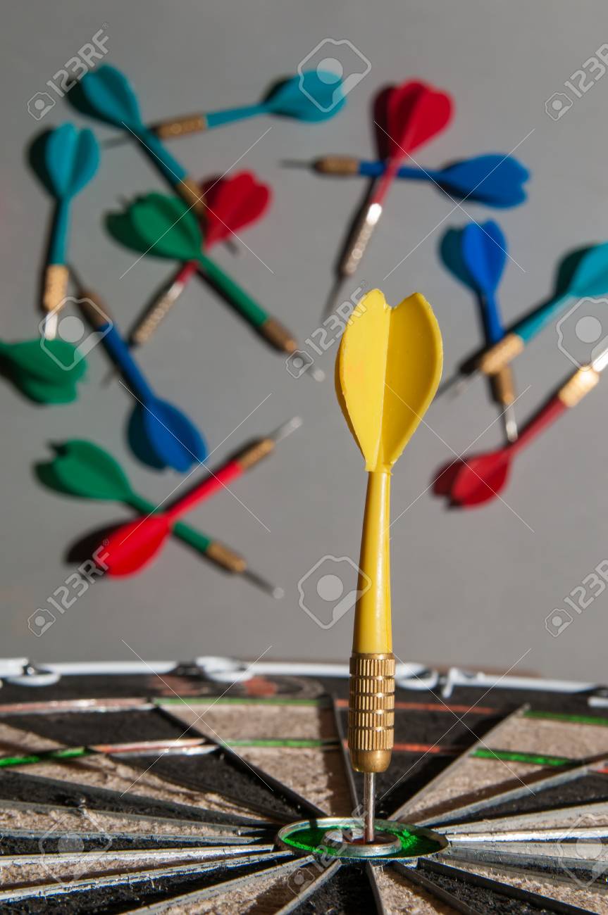 Yellow Dart On The Bullseye Of A Dartboard And Some Failed Shots