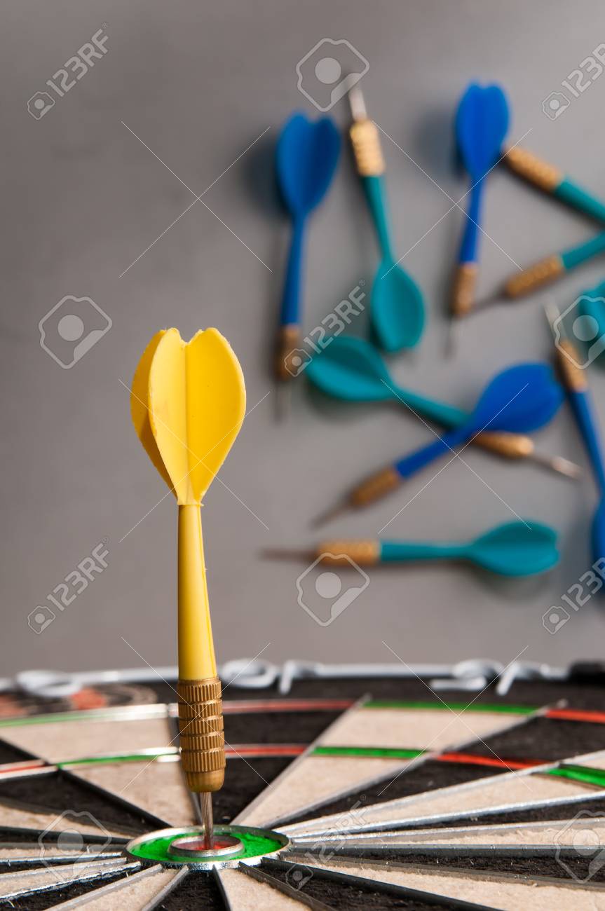 Yellow Dart On The Bullseye Of A Dartboard And Some Failed Shots