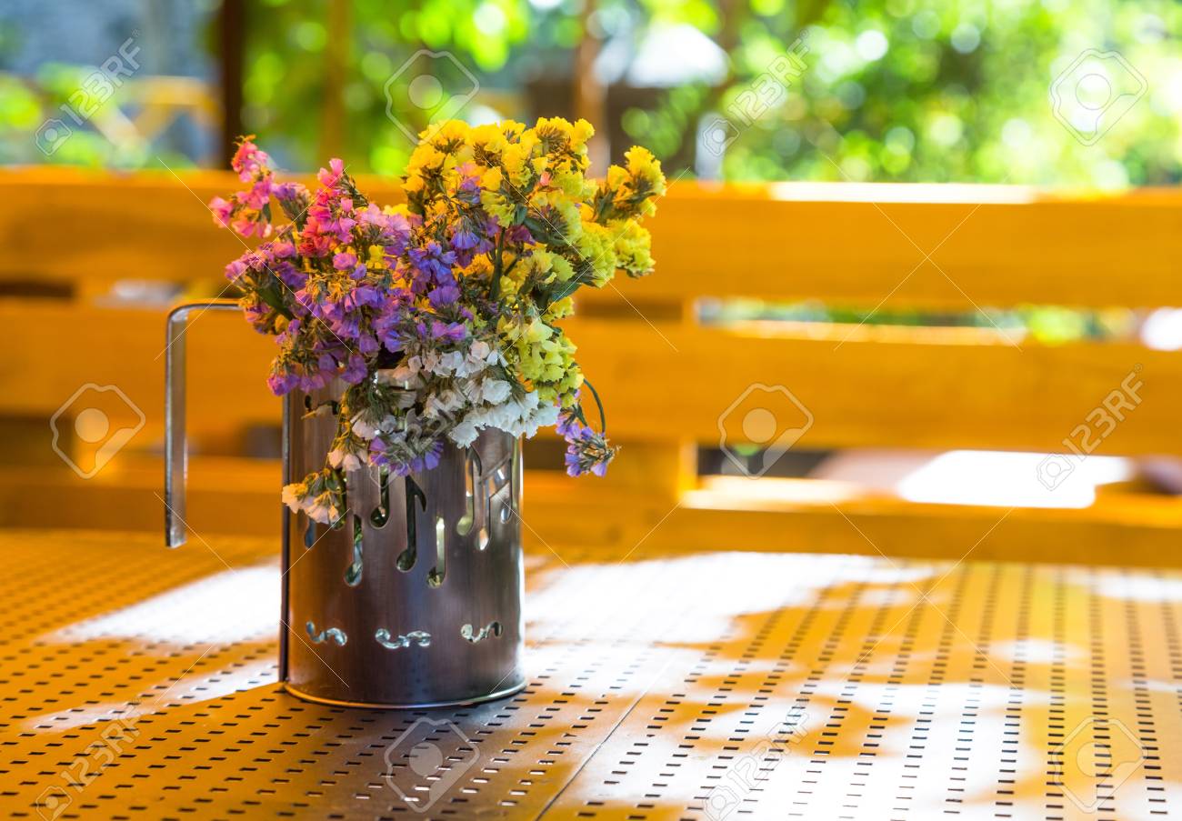 bunch of dry flowers in a cup standing on a table in the summer