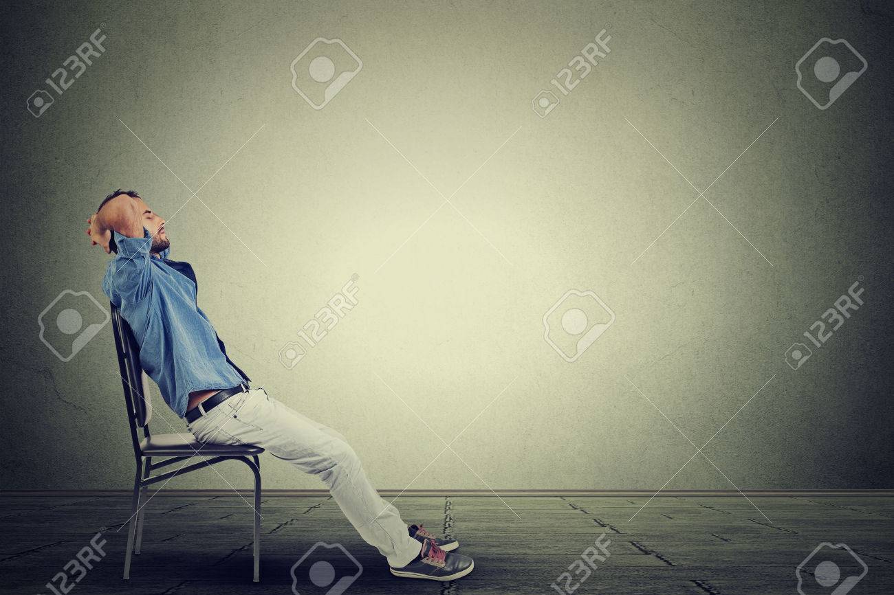 Side profile young business man relaxes in his empty office - 46737923 Side profile young business man relaxes in his empty office - 46737923