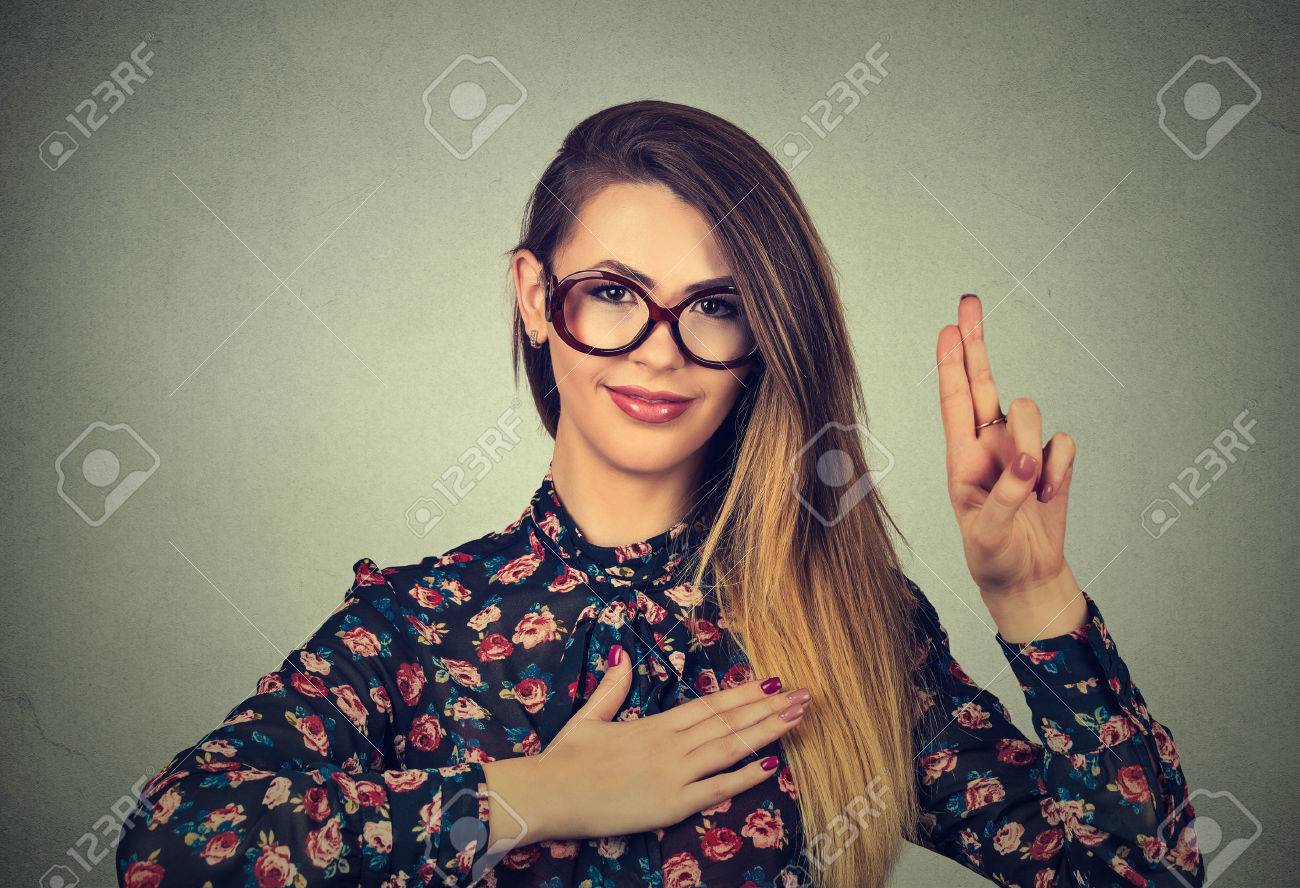 Young woman in glasses making a promise isolated on gray wall background - 55040249 Young woman in glasses making a promise isolated on gray wall background - 55040249
