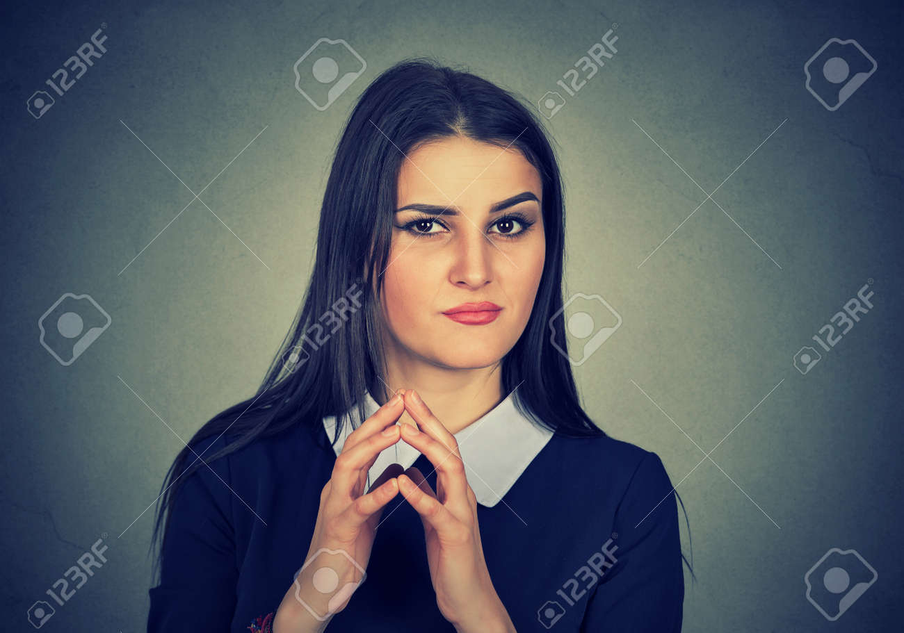 灰色の背景に分離された何かをプロット卑劣な陰険なたくらみの若い女性のポートレート クローズ アップ 人間の感情 表情 感情 態度を負します の写真素材 画像素材 Image