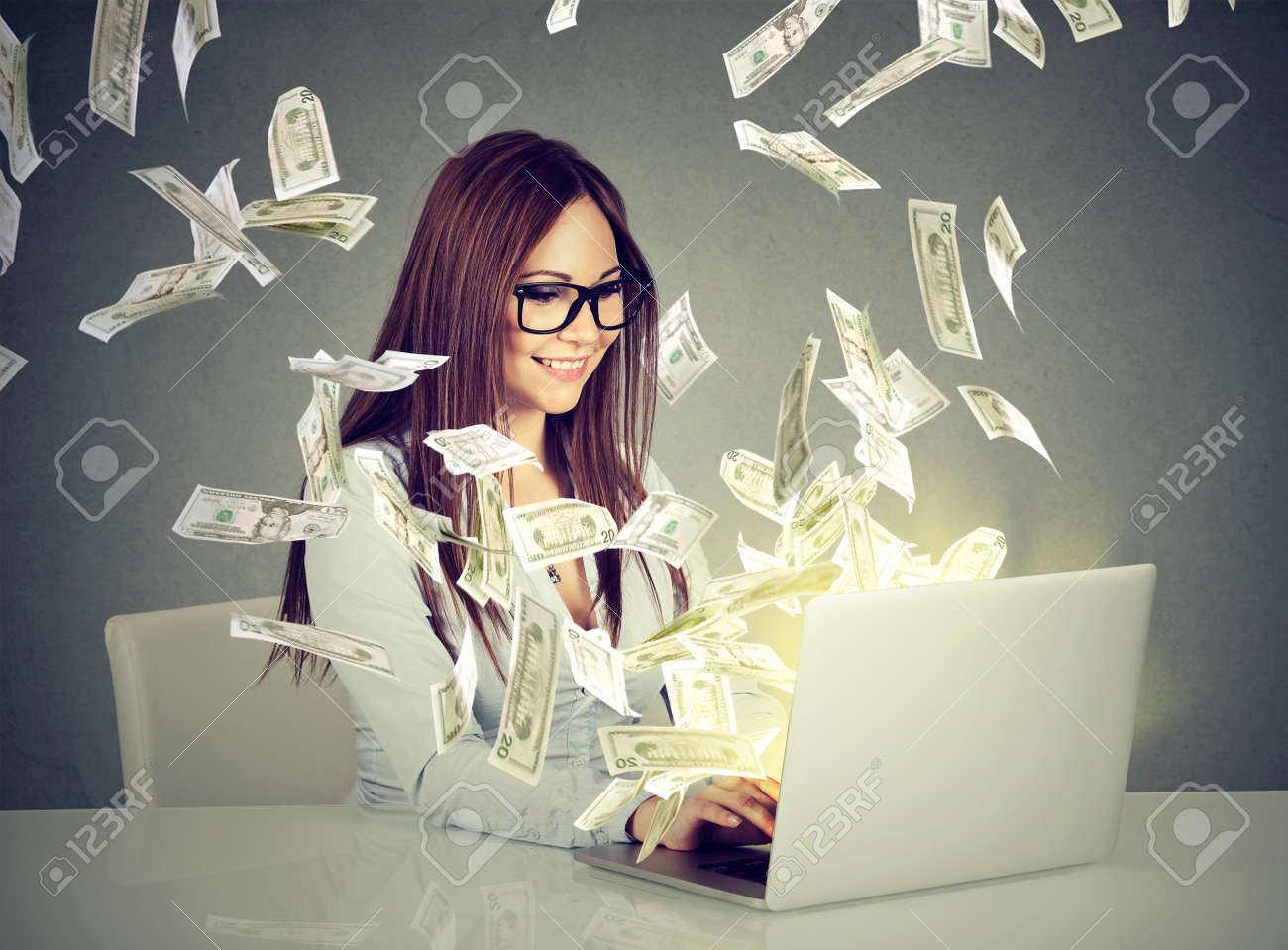 Professional smart young woman using a laptop building online business making money dollar bills cash coming out of computer. Beginner IT entrepreneur success economy concept - 74961839 Professional smart young woman using a laptop building online business making money dollar bills cash coming out of computer. Beginner IT entrepreneur success economy concept - 74961839