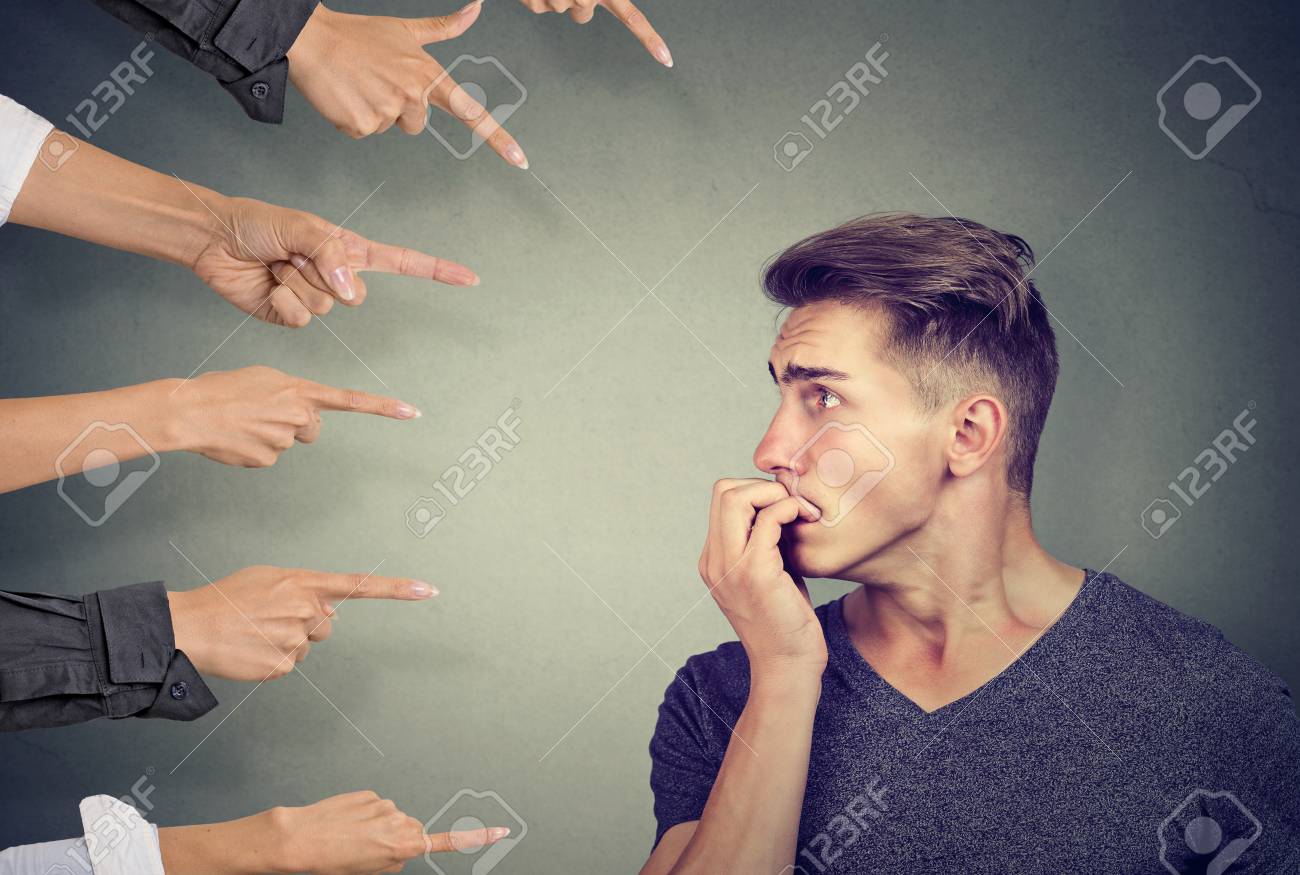 不安な人は異なる人々によって判断される 有罪の男の告発の概念 ネガティブな人間の感情は表情感を顔 の写真素材 画像素材 Image