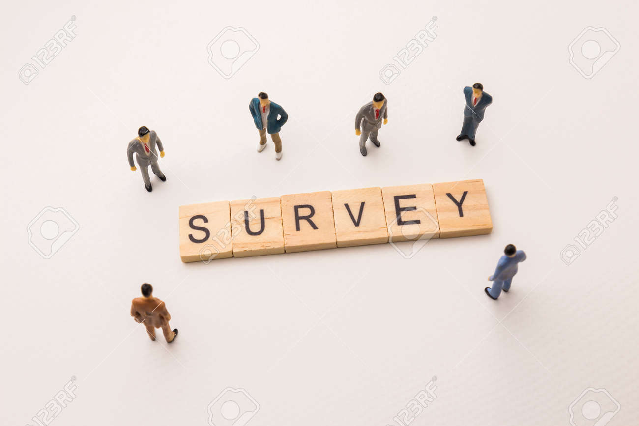 miniature figures businessman meeting on survey letters by survey letters
