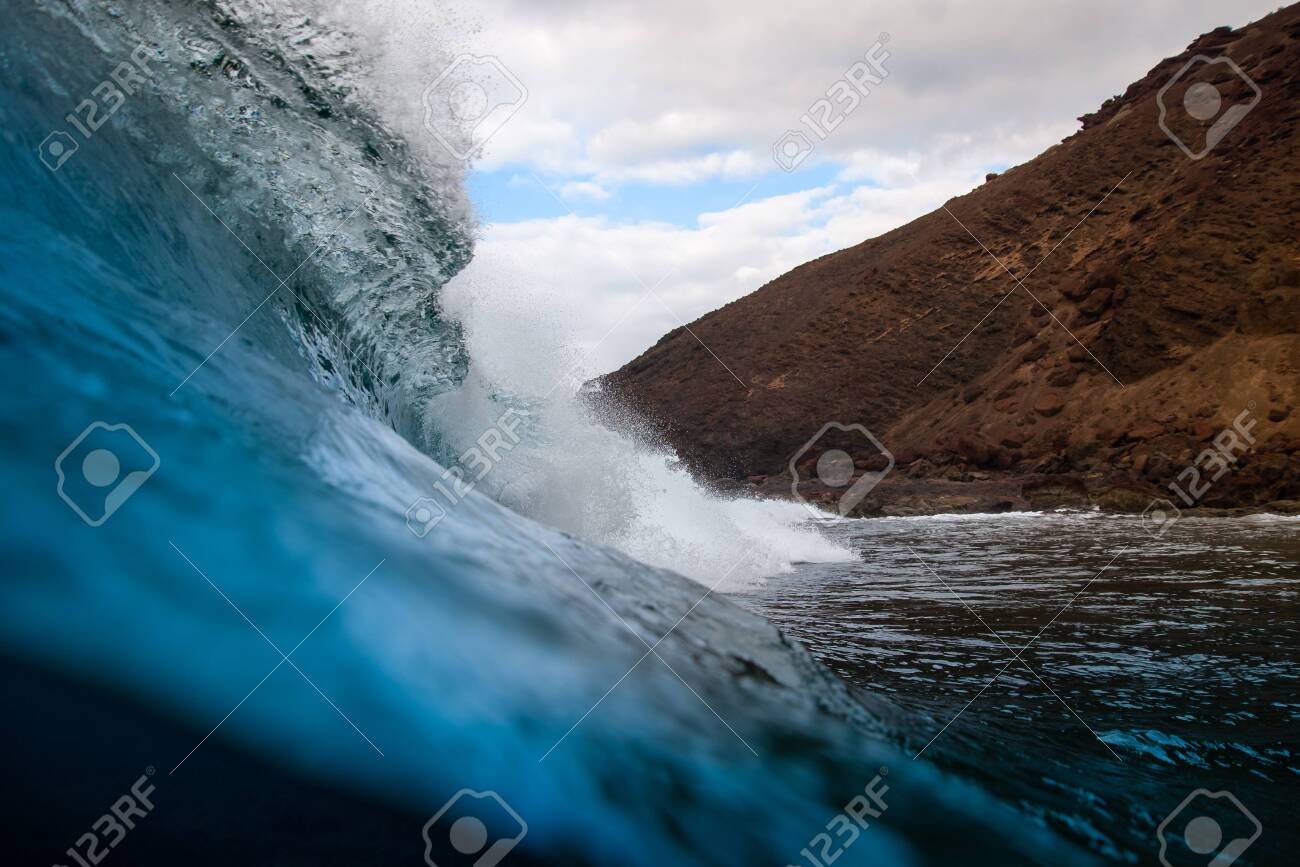 breaking wave with the tube and blue water with the clouds at the background - 139618275 breaking wave with the tube and blue water with the clouds at the background - 139618275