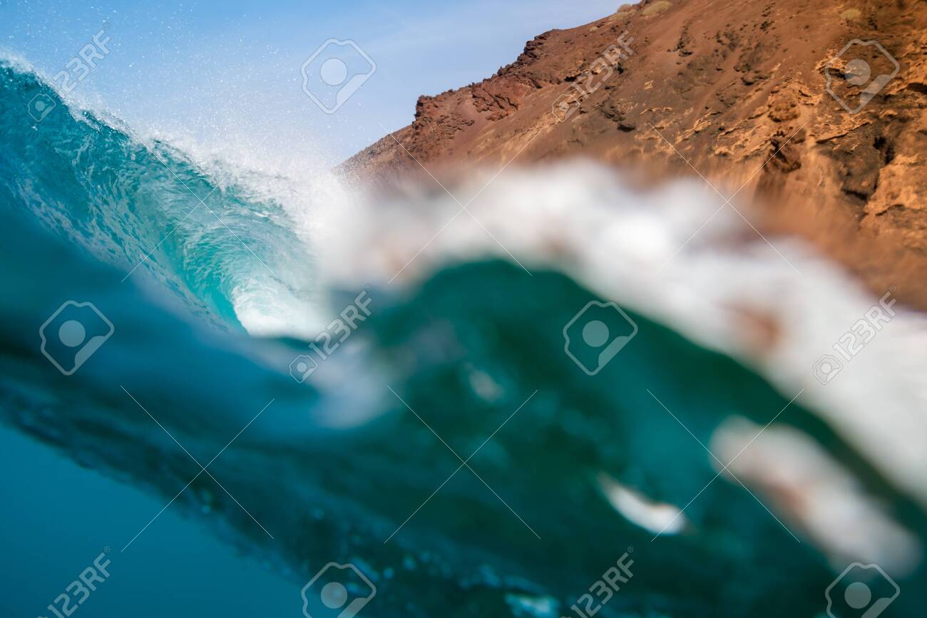 breaking wave with the tube and blue water with the clouds at the background - 141048149 breaking wave with the tube and blue water with the clouds at the background - 141048149