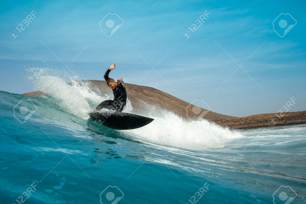 Surfer riding waves on the island of fuerteventura in the Atlantic Ocean, Canary Islands - 141083660 Surfer riding waves on the island of fuerteventura in the Atlantic Ocean, Canary Islands - 141083660
