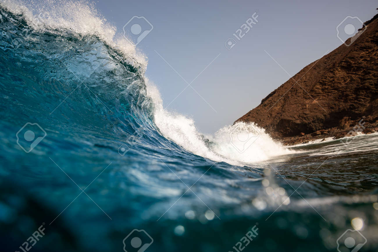 breaking wave with the tube and blue water with the clouds at the background - 142154246 breaking wave with the tube and blue water with the clouds at the background - 142154246