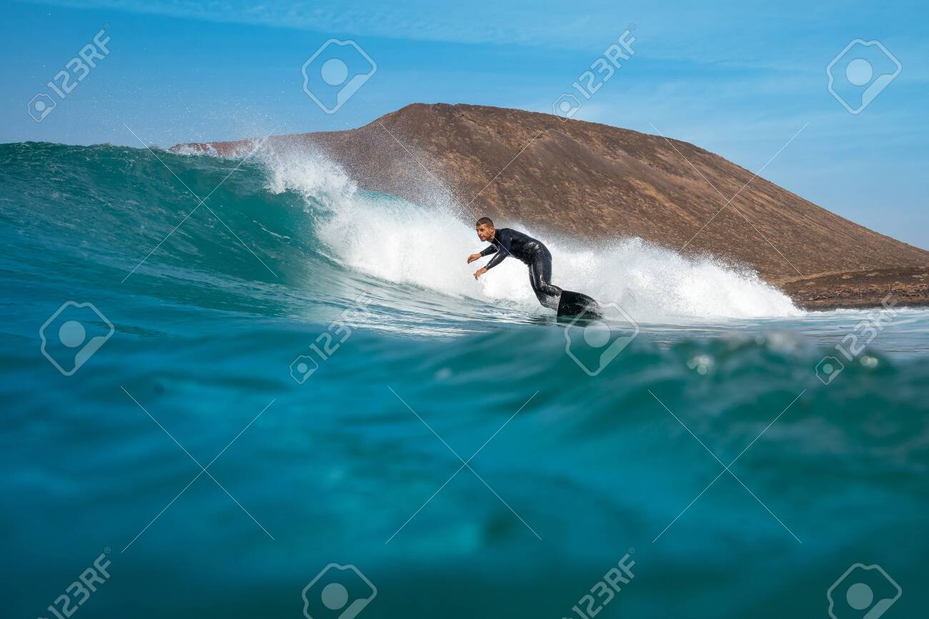 surfer riding waves on the island of fuerteventura - 143159816 surfer riding waves on the island of fuerteventura - 143159816
