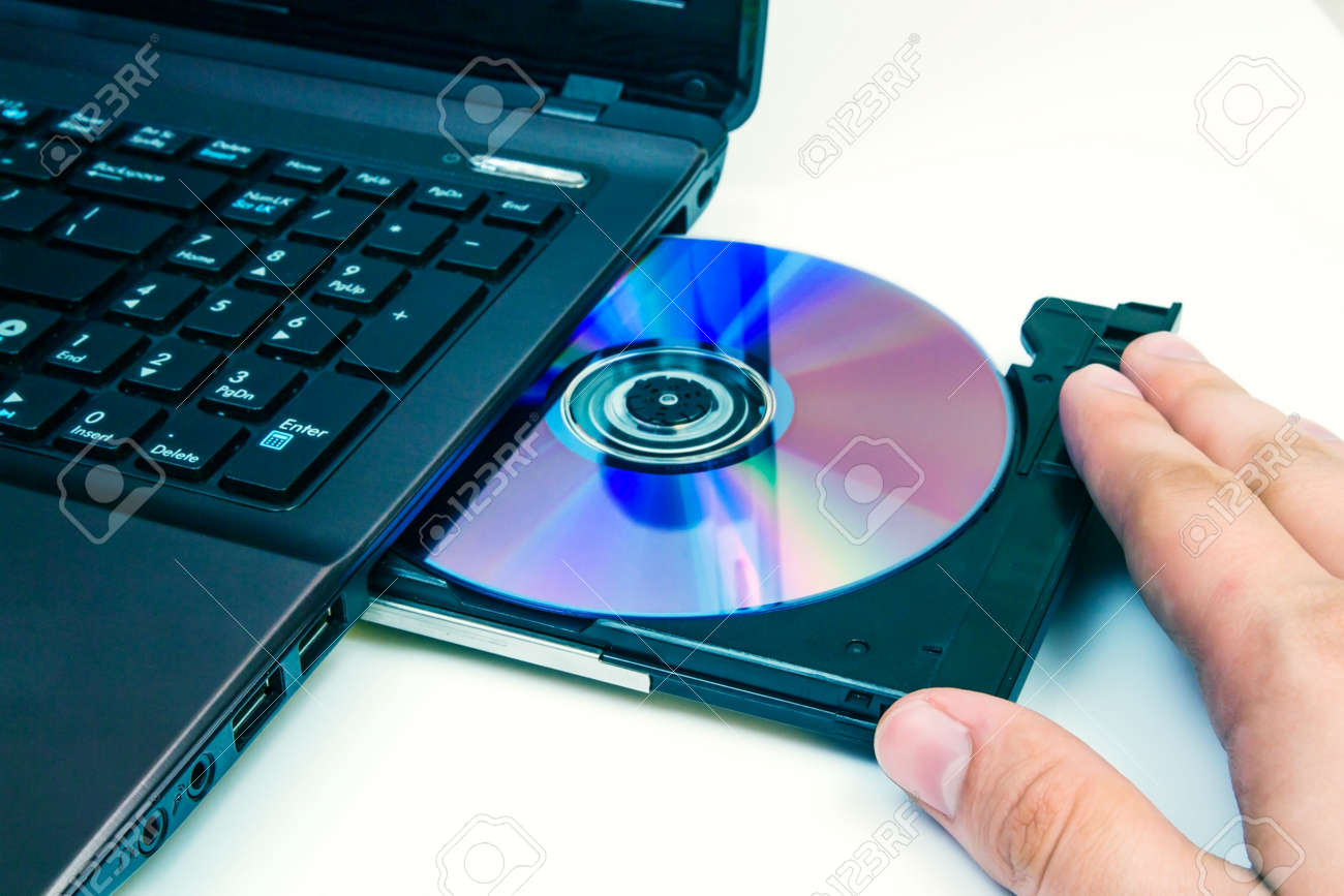 man insert compact disc from laptop stock photo picture and royalty insert cd