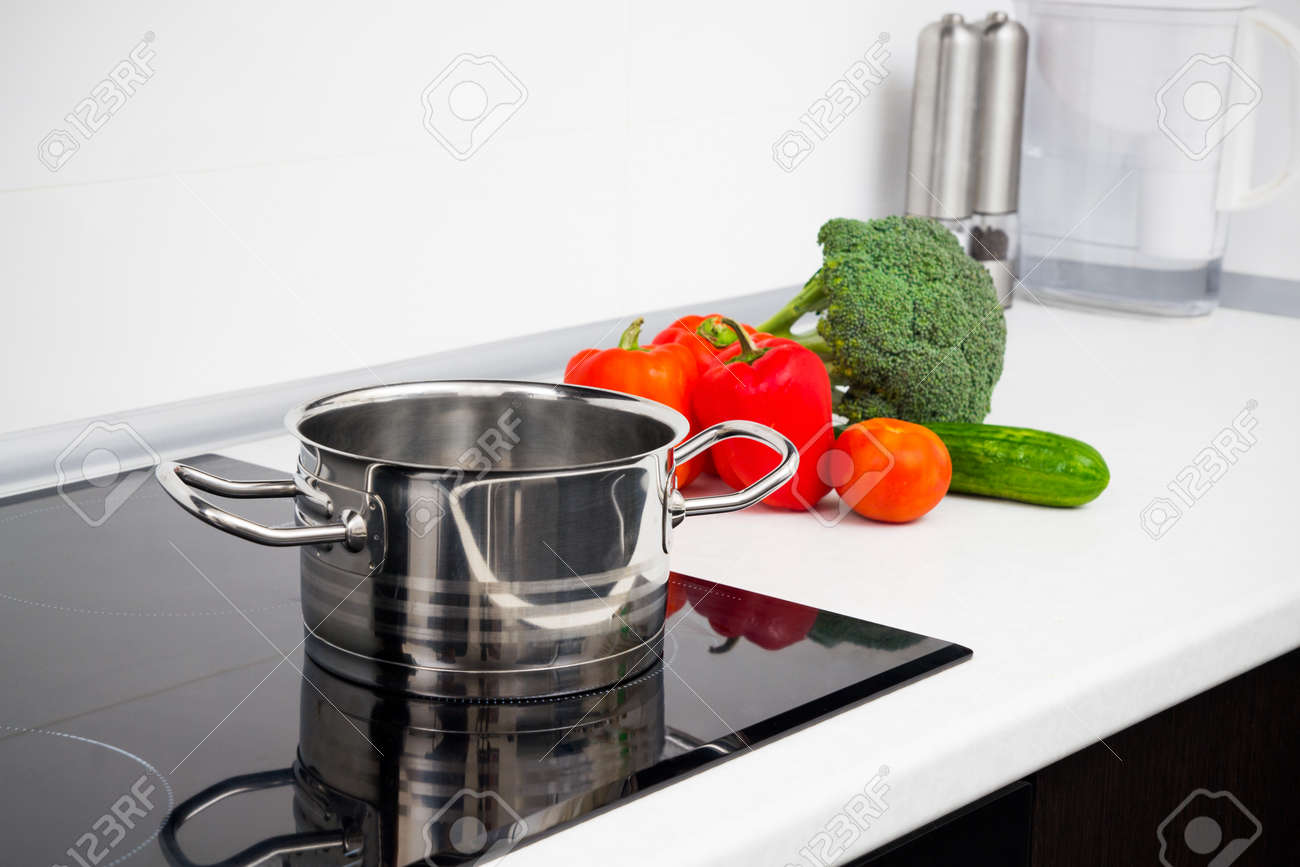 Pot And Vegetables In Modern Kitchen With Induction Stove Stock Pot And Vegetables In Modern Kitchen With Induction Stove Stock Photo 24246786