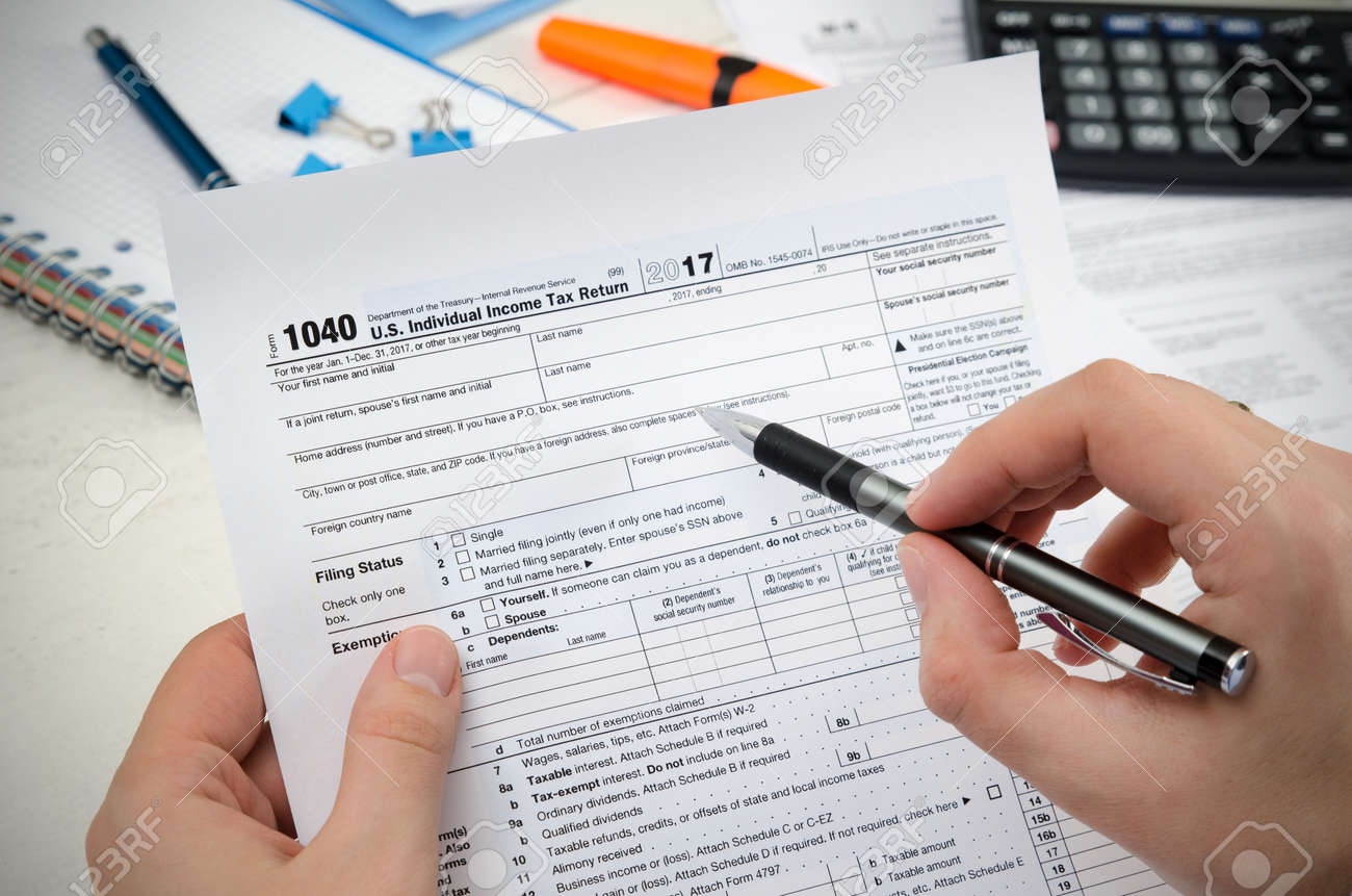 man filling us tax form tax form us business income office hand first name and initial tax form