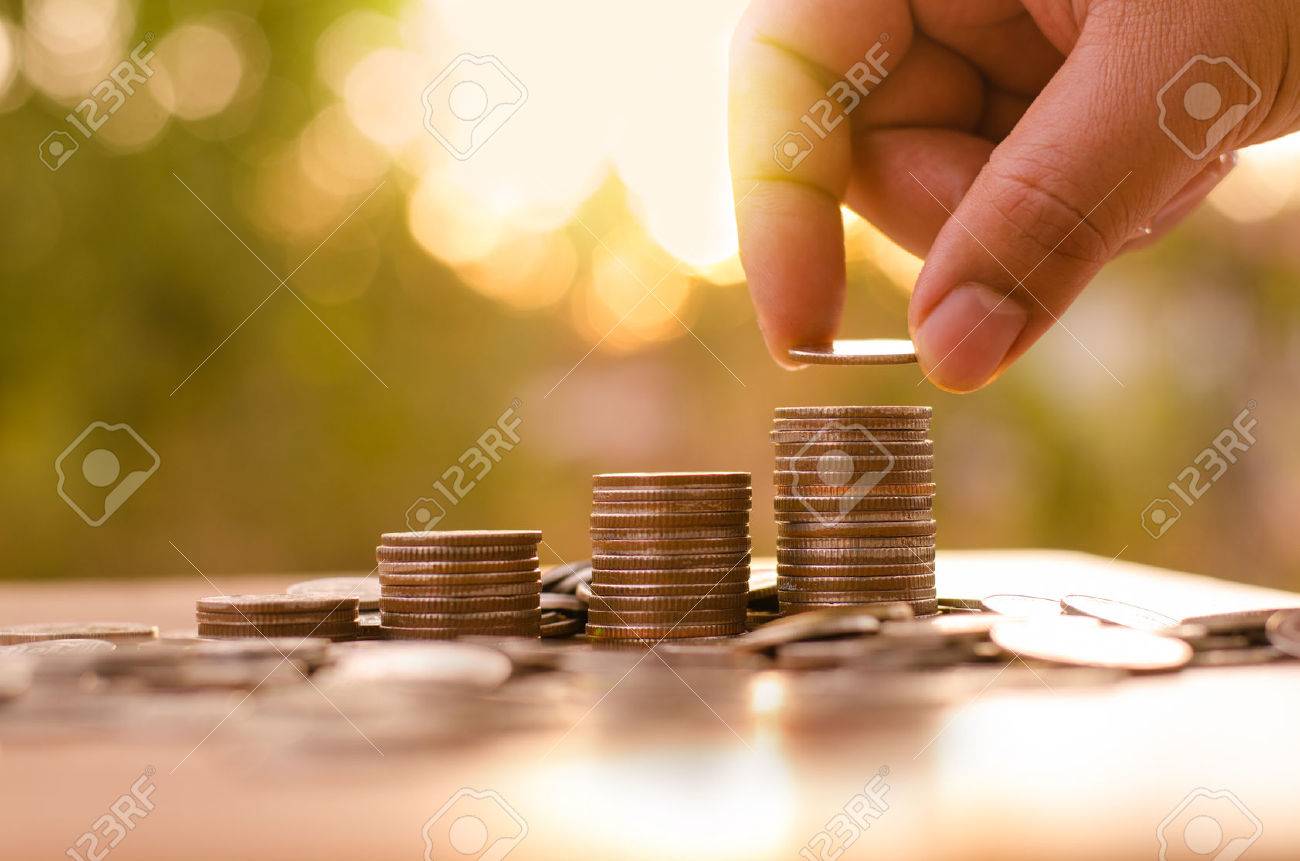 Male hand putting coin stack growing graph with sunlight - 36333071 Male hand putting coin stack growing graph with sunlight - 36333071