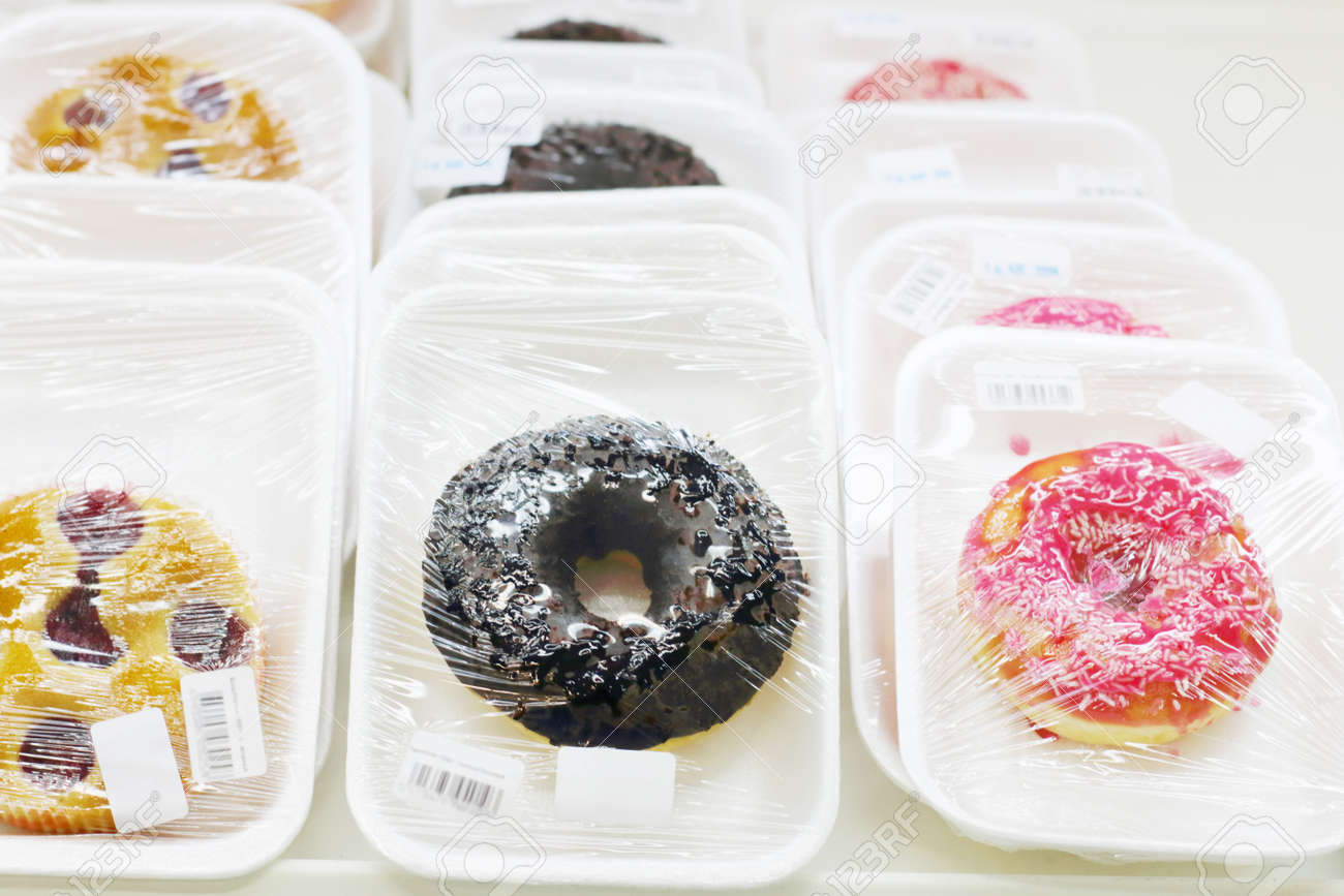 Many different sweet glazed donuts in plastic packaging in store - 34646108 Many different sweet glazed donuts in plastic packaging in store - 34646108