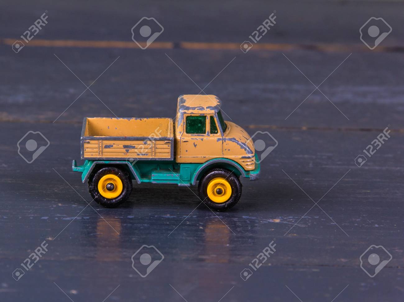 金属 木製の背景にオレンジ色のクローズ アップでトラックの古い 汚い ぼろぼろ 模型のおもちゃ の写真素材 画像素材 Image