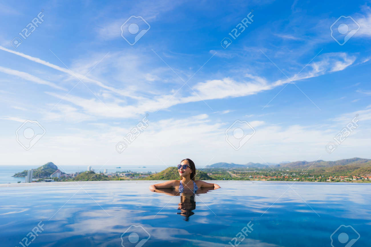 Portrait beautiful young asian woman smile happy relax around swimming pool in hotel resort for leisure travel and vacation concept - 122456273 Portrait beautiful young asian woman smile happy relax around swimming pool in hotel resort for leisure travel and vacation concept - 122456273