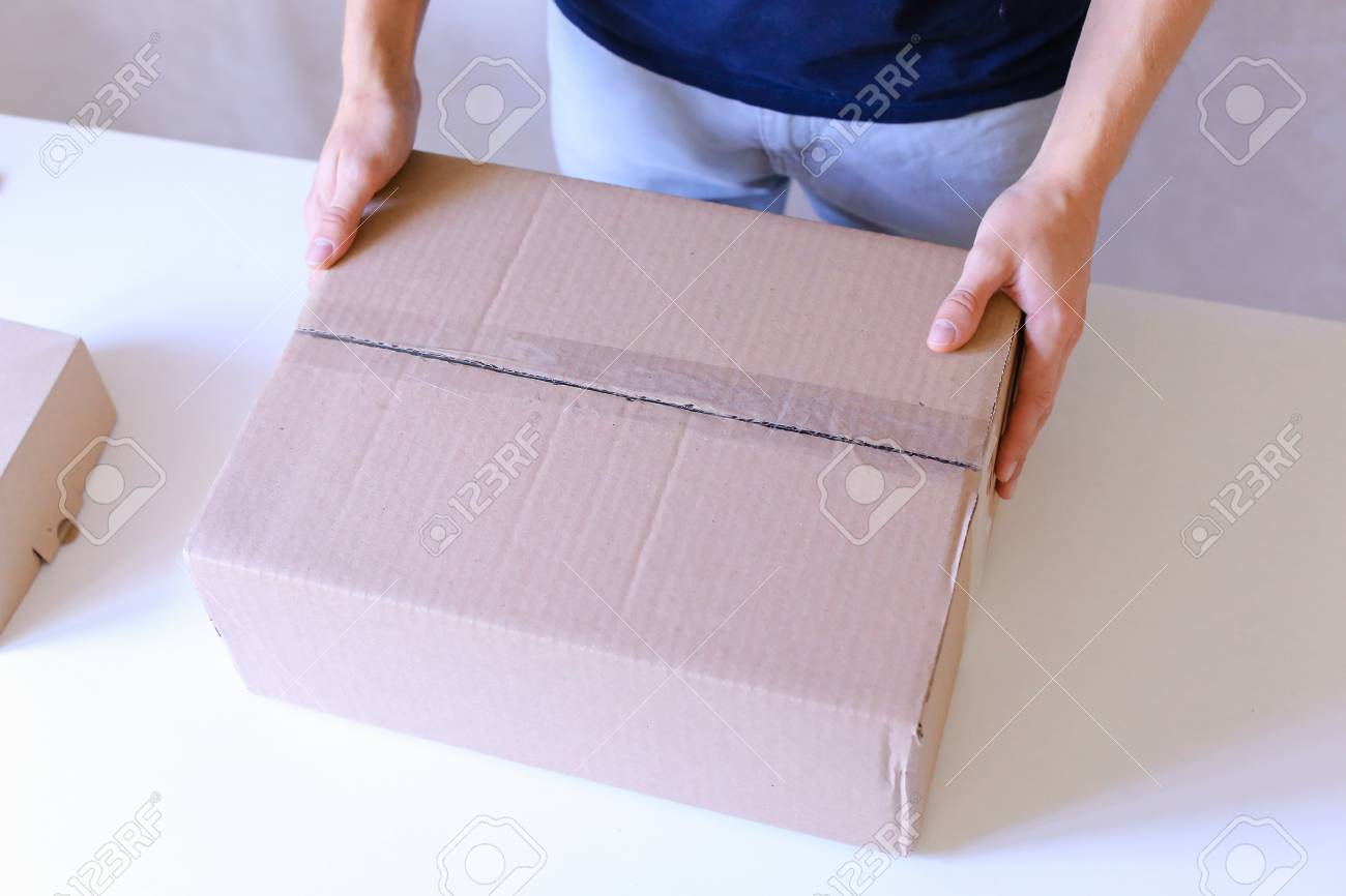 大きな箱の小さなボックス 郵便配達の仕事を非常によくダウンすべての側面 ターンと産むでテープで密封パック ボックス 郵便配達員のチェックノート パソコンを提供する送料と配達員によって商品 Bl で宅配便の梱包会社がアクセサリーの販売に特化します の写真素材